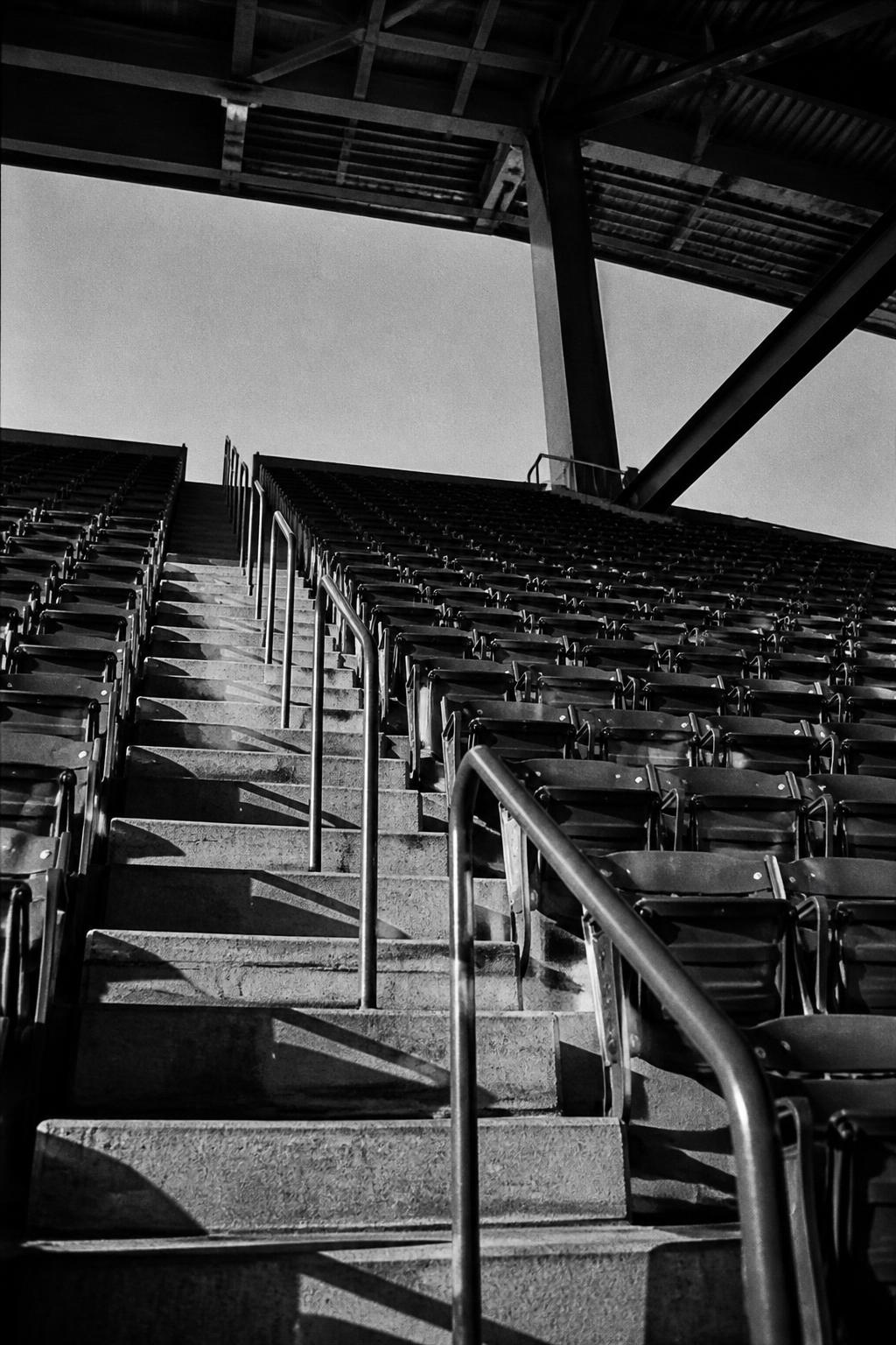 Empty stadium bleachers with hard diagonal shadows